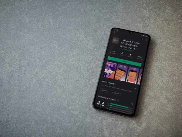 Lod, Israel - 8 Temmuz 2020: AllJobs uygulama oyun mağazası sayfası seramik taş zemin üzerinde siyah bir cep telefonu görüntüsü. Üst görünüm düzlüğü kopyalama alanı ile yatıyordu.