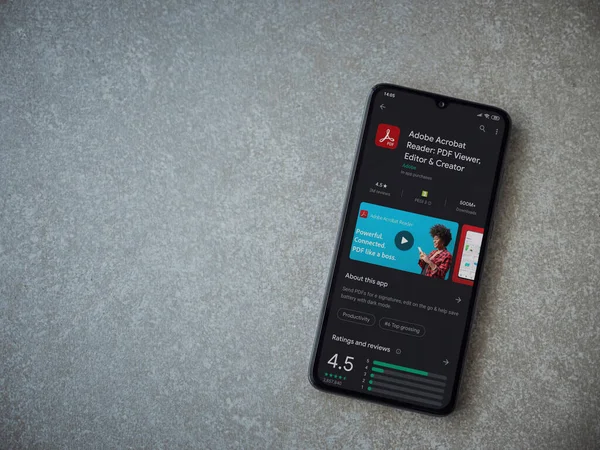 Lod, Israel - 8 Temmuz 2020: Adobe Acrobat Reader uygulama oyun mağazası sayfası seramik taş zemin üzerinde siyah bir cep telefonu görüntüsü. Üst görünüm düzlüğü kopyalama alanı ile yatıyordu.