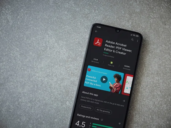 Lod, Israel - 8 Temmuz 2020: Adobe Acrobat Reader uygulama oyun mağazası sayfası seramik taş zemin üzerinde siyah bir cep telefonu görüntüsü. Üst görünüm düzlüğü kopyalama alanı ile yatıyordu.