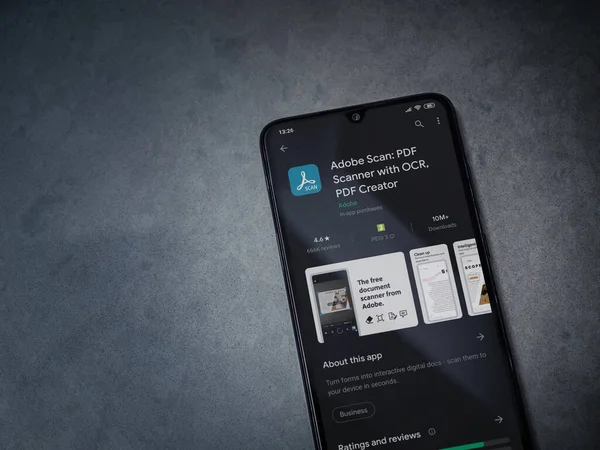 Lod, Israel - 8 Temmuz 2020: Adobe Scan uygulama oyun mağazası sayfası koyu mermer taşlı arka planda siyah bir cep telefonu görüntüsü. Üst görünüm düzlüğü kopyalama alanı ile yatıyordu.