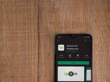 Lod, Israel - 8 Temmuz 2020: Freelancers uygulama oyun mağazası sayfası için ahşap arka planda siyah bir cep telefonu görüntüsü. Üst görünüm düzlüğü kopyalama alanı ile yatıyordu.