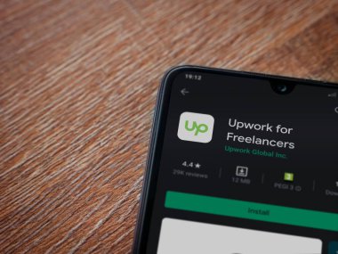 Lod, Israel - 8 Temmuz 2020: Freelancers uygulama oyun mağazası sayfası için ahşap arka planda siyah bir cep telefonu görüntüsü. Üst görünüm düzlüğü kopyalama alanı ile yatıyordu.