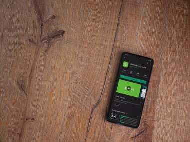 Lod, Israel - 8 Temmuz 2020: Müşteriler için Güncelleme uygulaması oyun mağazası sayfası ahşap arka planda siyah bir cep telefonu ekranında. Üst görünüm düzlüğü kopyalama alanı ile yatıyordu.