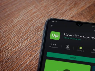 Lod, Israel - 8 Temmuz 2020: Müşteriler için Güncelleme uygulaması oyun mağazası sayfası ahşap arka planda siyah bir cep telefonu ekranında. Üst görünüm düzlüğü kopyalama alanı ile yatıyordu.