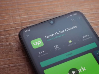 Lod, Israel - 8 Temmuz 2020: Müşteriler için Güncelleme uygulaması oyun mağazası sayfası ahşap arka planda siyah bir cep telefonu ekranında. Üst görünüm düzlüğü kopyalama alanı ile yatıyordu.