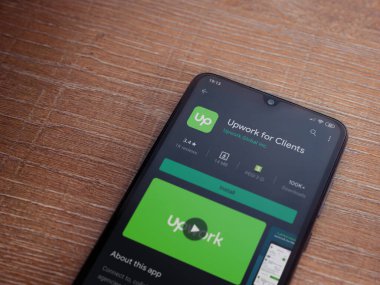 Lod, Israel - 8 Temmuz 2020: Müşteriler için Güncelleme uygulaması oyun mağazası sayfası ahşap arka planda siyah bir cep telefonu ekranında. Üst görünüm düzlüğü kopyalama alanı ile yatıyordu.