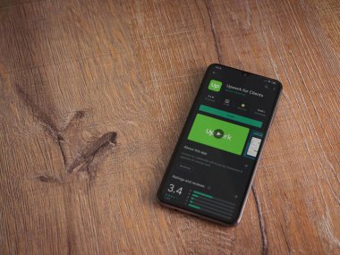 Lod, Israel - 8 Temmuz 2020: Müşteriler için Güncelleme uygulaması oyun mağazası sayfası ahşap arka planda siyah bir cep telefonu ekranında. Üst görünüm düzlüğü kopyalama alanı ile yatıyordu.