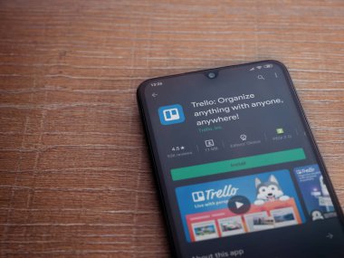 Lod, Israel - 8 Temmuz 2020: Trello uygulama oyun mağazası sayfası ahşap arka planda siyah bir cep telefonunun ekranında. Üst görünüm düzlüğü kopyalama alanı ile yatıyordu.