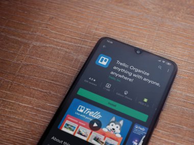 Lod, Israel - 8 Temmuz 2020: Trello uygulama oyun mağazası sayfası ahşap arka planda siyah bir cep telefonunun ekranında. Üst görünüm düzlüğü kopyalama alanı ile yatıyordu.