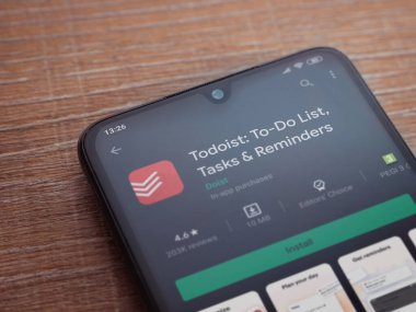 Lod, Israel - 8 Temmuz 2020: Todoist uygulama oyun mağazası sayfası ahşap arka planda siyah bir cep telefonunun ekranında. Üst görünüm düzlüğü kopyalama alanı ile yatıyordu.