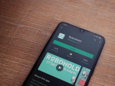 Lod, Israel - 8 Temmuz 2020: RoboHold uygulama oyun mağazası sayfası ahşap arka planda siyah bir cep telefonu ekranında. Üst görünüm düzlüğü kopyalama alanı ile yatıyordu.