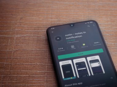 Lod, Israel - 8 Temmuz 2020: Uygulama oyun mağazası sayfasında ahşap arka planda siyah bir cep telefonu görüntüsü yok. Üst görünüm düzlüğü kopyalama alanı ile yatıyordu.