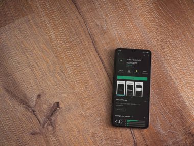 Lod, Israel - 8 Temmuz 2020: Uygulama oyun mağazası sayfasında ahşap arka planda siyah bir cep telefonu görüntüsü yok. Üst görünüm düzlüğü kopyalama alanı ile yatıyordu.