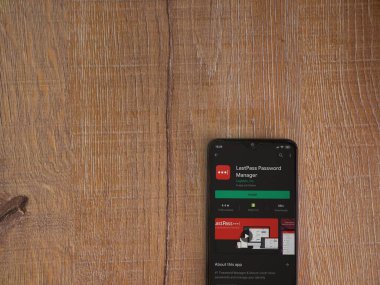Lod, Israel - 8 Temmuz 2020: LastPass Şifre Yöneticisi uygulama oyun mağazası sayfası ahşap arka planda siyah bir cep telefonu sergilenmektedir. Üst görünüm düzlüğü kopyalama alanı ile yatıyordu.
