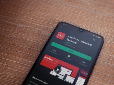Lod, Israel - 8 Temmuz 2020: LastPass Şifre Yöneticisi uygulama oyun mağazası sayfası ahşap arka planda siyah bir cep telefonu sergilenmektedir. Üst görünüm düzlüğü kopyalama alanı ile yatıyordu.