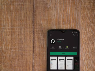 Lod, Israel - 8 Temmuz 2020: GitHub uygulama oyun mağazası sayfası ahşap arka planda siyah bir cep telefonunun ekranında. Üst görünüm düzlüğü kopyalama alanı ile yatıyordu.