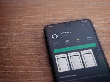 Lod, Israel - 8 Temmuz 2020: GitHub uygulama oyun mağazası sayfası ahşap arka planda siyah bir cep telefonunun ekranında. Üst görünüm düzlüğü kopyalama alanı ile yatıyordu.