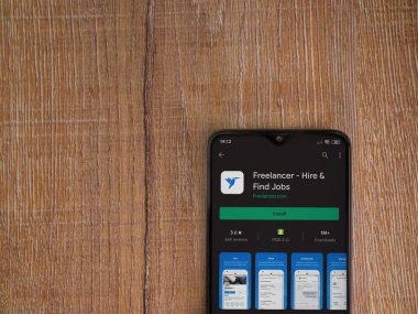 Lod, Israel - 8 Temmuz 2020: Freelancer uygulama oyun mağazası sayfası ahşap arka planda siyah bir cep telefonunun ekranında. Üst görünüm düzlüğü kopyalama alanı ile yatıyordu.