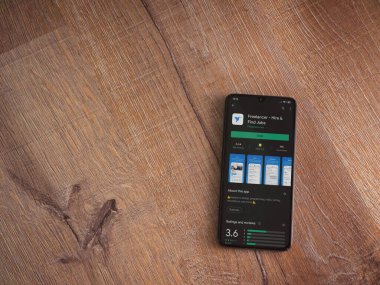 Lod, Israel - 8 Temmuz 2020: Freelancer uygulama oyun mağazası sayfası ahşap arka planda siyah bir cep telefonunun ekranında. Üst görünüm düzlüğü kopyalama alanı ile yatıyordu.