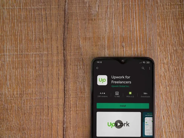 Lod, Israel - 8 Temmuz 2020: Freelancers uygulama oyun mağazası sayfası için ahşap arka planda siyah bir cep telefonu görüntüsü. Üst görünüm düzlüğü kopyalama alanı ile yatıyordu.