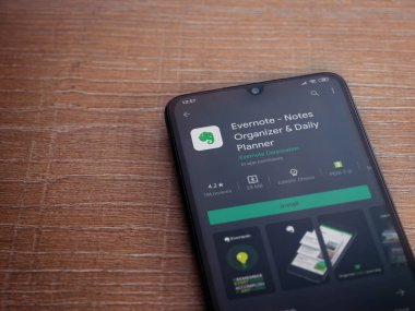 Lod, Israel - 8 Temmuz 2020: Evernote uygulaması oyun mağazası sayfası ahşap arka planda siyah bir cep telefonunun ekranında. Üst görünüm düzlüğü kopyalama alanı ile yatıyordu.