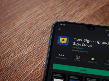 Lod, Israel - 8 Temmuz 2020: Docusign uygulama oyun mağazası sayfası ahşap arka planda siyah bir cep telefonunun ekranında. Üst görünüm düzlüğü kopyalama alanı ile yatıyordu.