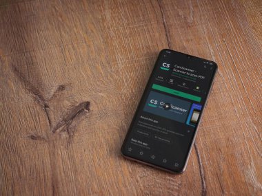 Lod, Israel - 8 Temmuz 2020: CamScanner uygulama oyun mağazası sayfası ahşap arka planda siyah bir cep telefonunun ekranında. Üst görünüm düzlüğü kopyalama alanı ile yatıyordu.
