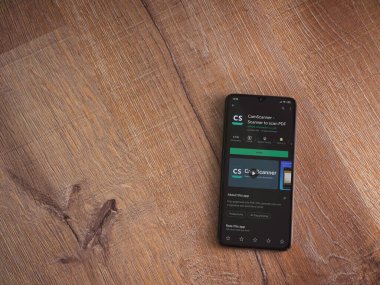 Lod, Israel - 8 Temmuz 2020: CamScanner uygulama oyun mağazası sayfası ahşap arka planda siyah bir cep telefonunun ekranında. Üst görünüm düzlüğü kopyalama alanı ile yatıyordu.
