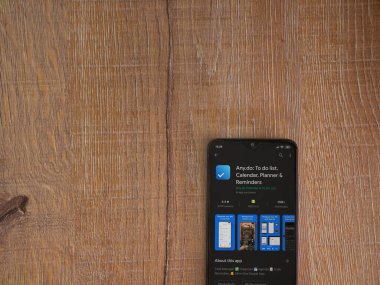 Lod, Israel - 8 Temmuz 2020: Herhangi bir uygulama oyun mağazası sayfası ahşap arka planda siyah bir cep telefonu ekranında. Üst görünüm düzlüğü kopyalama alanı ile yatıyordu.
