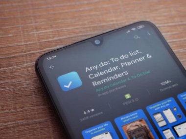 Lod, Israel - 8 Temmuz 2020: Herhangi bir uygulama oyun mağazası sayfası ahşap arka planda siyah bir cep telefonu ekranında. Üst görünüm düzlüğü kopyalama alanı ile yatıyordu.