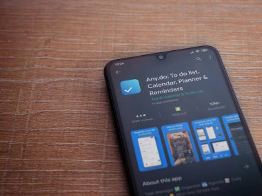 Lod, Israel - 8 Temmuz 2020: Herhangi bir uygulama oyun mağazası sayfası ahşap arka planda siyah bir cep telefonu ekranında. Üst görünüm düzlüğü kopyalama alanı ile yatıyordu.