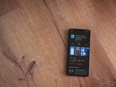 Lod, Israel - 8 Temmuz 2020: Herhangi bir uygulama oyun mağazası sayfası ahşap arka planda siyah bir cep telefonu ekranında. Üst görünüm düzlüğü kopyalama alanı ile yatıyordu.