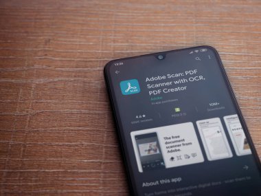 Lod, Israel - 8 Temmuz 2020: Adobe Scan uygulaması oyun mağazası sayfası ahşap arka planda siyah bir cep telefonu ekranında. Üst görünüm düzlüğü kopyalama alanı ile yatıyordu.