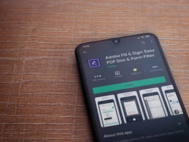 Lod, Israel - 8 Temmuz 2020: Adobe Doldur & İmzala uygulaması oyun mağazası sayfası, ahşap arka planda siyah bir cep telefonu görüntüsü. Üst görünüm düzlüğü kopyalama alanı ile yatıyordu.