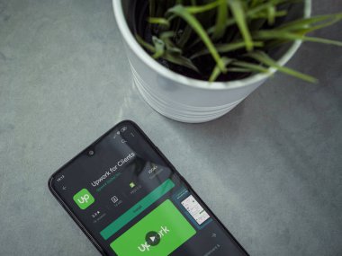 Lod, Israel - 8 Temmuz 2020: Modern minimalist ofis çalışma alanı ve Upwork for Clients uygulaması oyun mağazası sayfası mermer arka planda. Üst görünüm düzlüğü kopyalama alanı ile yatıyordu.