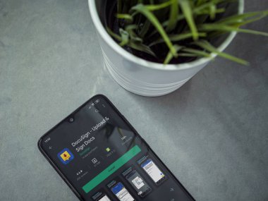 Lod, Israel - 8 Temmuz 2020: Mermer arka planda Docusign uygulaması oyun mağazası sayfası olan siyah cep telefonlu modern minimalist ofis çalışma alanı. Üst görünüm düzlüğü kopyalama alanı ile yatıyordu.