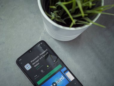 Lod, Israel - 8 Temmuz 2020: Modern minimalist ofis çalışma alanı ve siyah cep telefonu ile 1Password uygulama oyun mağazası sayfası mermer zemin üzerinde. Üst görünüm düzlüğü kopyalama alanı ile yatıyordu.