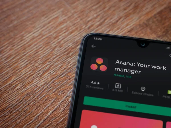 Lod, Israel - 8 Temmuz 2020: Asana uygulama oyun mağazası sayfası ahşap arka planda siyah bir cep telefonu ekranında. Üst görünüm düzlüğü kopyalama alanı ile yatıyordu.