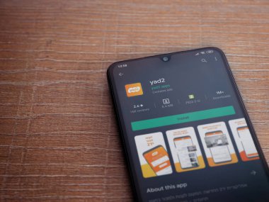 Lod, Israel - 8 Temmuz 2020: yad2 uygulama oyun mağazası sayfası ahşap arka planda siyah bir cep telefonunun ekranında. Üst görünüm düzlüğü kopyalama alanı ile yatıyordu.