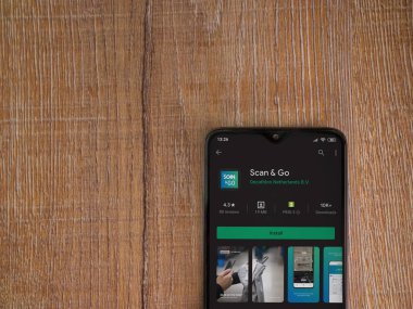 Lod, Israel - 8 Temmuz 2020: Ahşap arka planda siyah bir cep telefonunun ekranında uygulamalı oyun mağazası sayfasını tara. Üst görünüm düzlüğü kopyalama alanı ile yatıyordu.