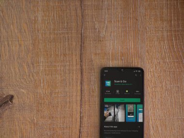 Lod, Israel - 8 Temmuz 2020: Ahşap arka planda siyah bir cep telefonunun ekranında uygulamalı oyun mağazası sayfasını tara. Üst görünüm düzlüğü kopyalama alanı ile yatıyordu.