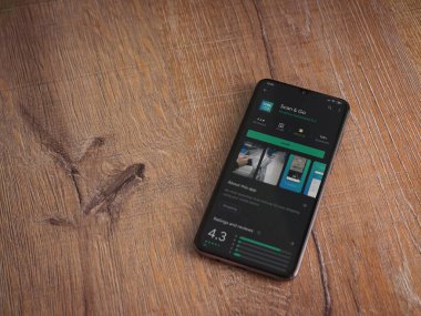 Lod, Israel - 8 Temmuz 2020: Ahşap arka planda siyah bir cep telefonunun ekranında uygulamalı oyun mağazası sayfasını tara. Üst görünüm düzlüğü kopyalama alanı ile yatıyordu.