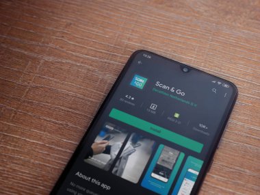 Lod, Israel - 8 Temmuz 2020: Ahşap arka planda siyah bir cep telefonunun ekranında uygulamalı oyun mağazası sayfasını tara. Üst görünüm düzlüğü kopyalama alanı ile yatıyordu.