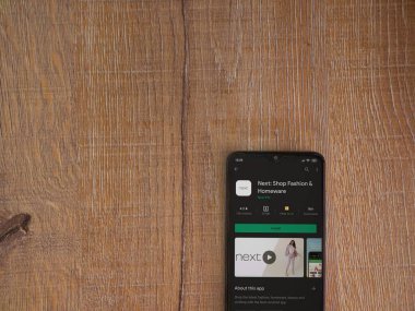 Lod, Israel - 8 Temmuz 2020: Sonraki uygulama oyun mağazası sayfası ahşap arka planda siyah bir cep telefonunun ekranında. Üst görünüm düzlüğü kopyalama alanı ile yatıyordu.