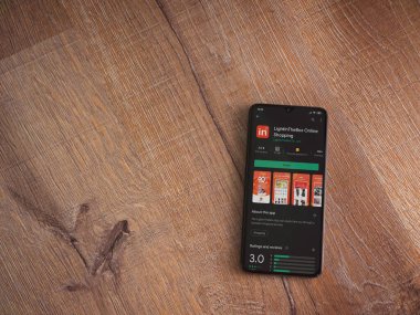 Lod, Israel - 8 Temmuz 2020: Ahşap arka planda siyah bir cep telefonunun ekranında uygulamalı oyun mağazası sayfasını aydınlat. Üst görünüm düzlüğü kopyalama alanı ile yatıyordu.