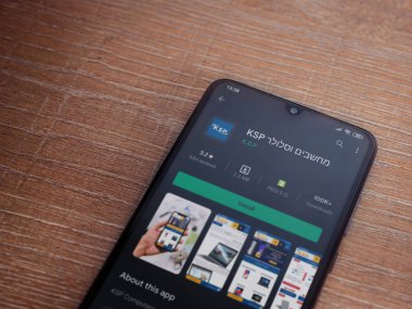 Lod, Israel - 8 Temmuz 2020: KSP uygulama oyun mağazası sayfası ahşap arka planda siyah bir cep telefonunun ekranında. Üst görünüm düzlüğü kopyalama alanı ile yatıyordu.