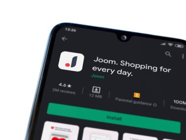 Lod, Israel - 8 Temmuz 2020: Beyaz arka planda izole edilmiş siyah bir cep telefonunun ekranında Joom uygulaması oyun mağazası sayfası. Üst görünüm düzlüğü kopyalama alanı ile yatıyordu.