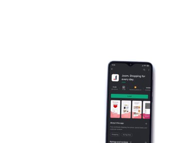 Lod, Israel - 8 Temmuz 2020: Beyaz arka planda izole edilmiş siyah bir cep telefonunun ekranında Joom uygulaması oyun mağazası sayfası. Üst görünüm düzlüğü kopyalama alanı ile yatıyordu.
