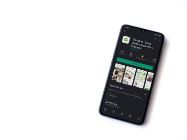 Lod, Israel - 8 Temmuz 2020: Groupon uygulaması oyun mağazası sayfası beyaz arka planda izole edilmiş siyah bir cep telefonu ekranında. Üst görünüm düzlüğü kopyalama alanı ile yatıyordu.