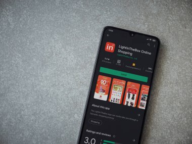 Lod, Israel - 8 Temmuz 2020: Seramik taştan arka planda siyah bir cep telefonunun ekranında uygulamalı oyun mağazası sayfasını aydınlat. Üst görünüm düzlüğü kopyalama alanı ile yatıyordu.